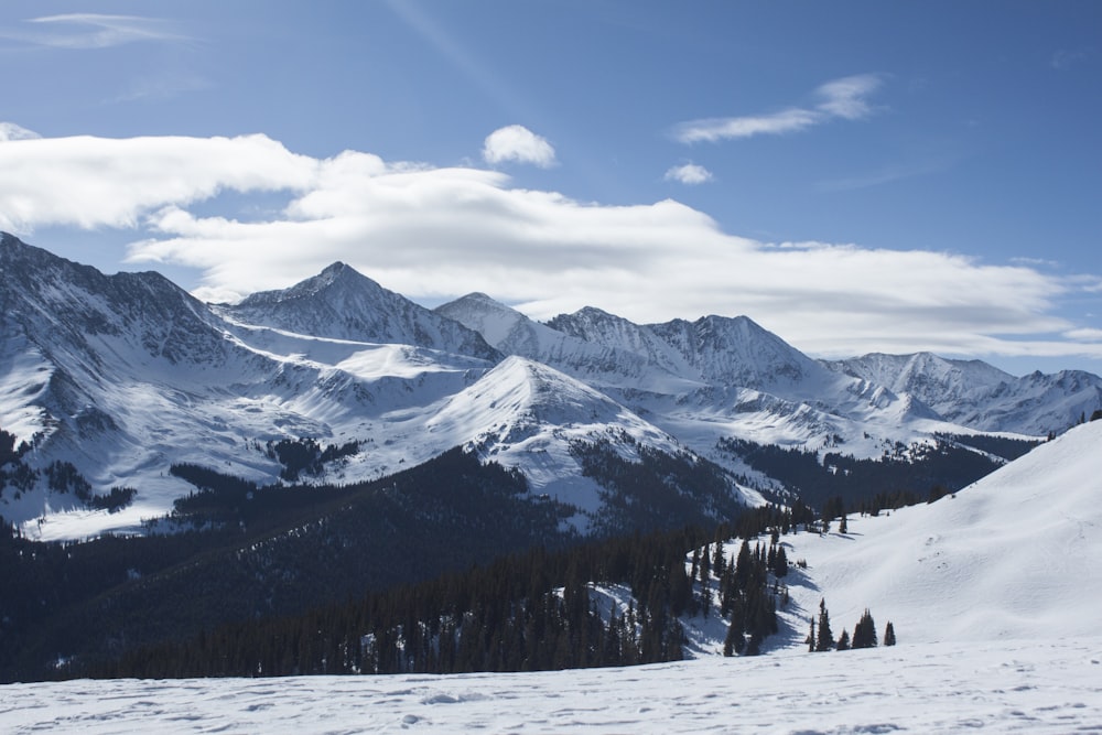 snow covered mountain under blue cloudy skies