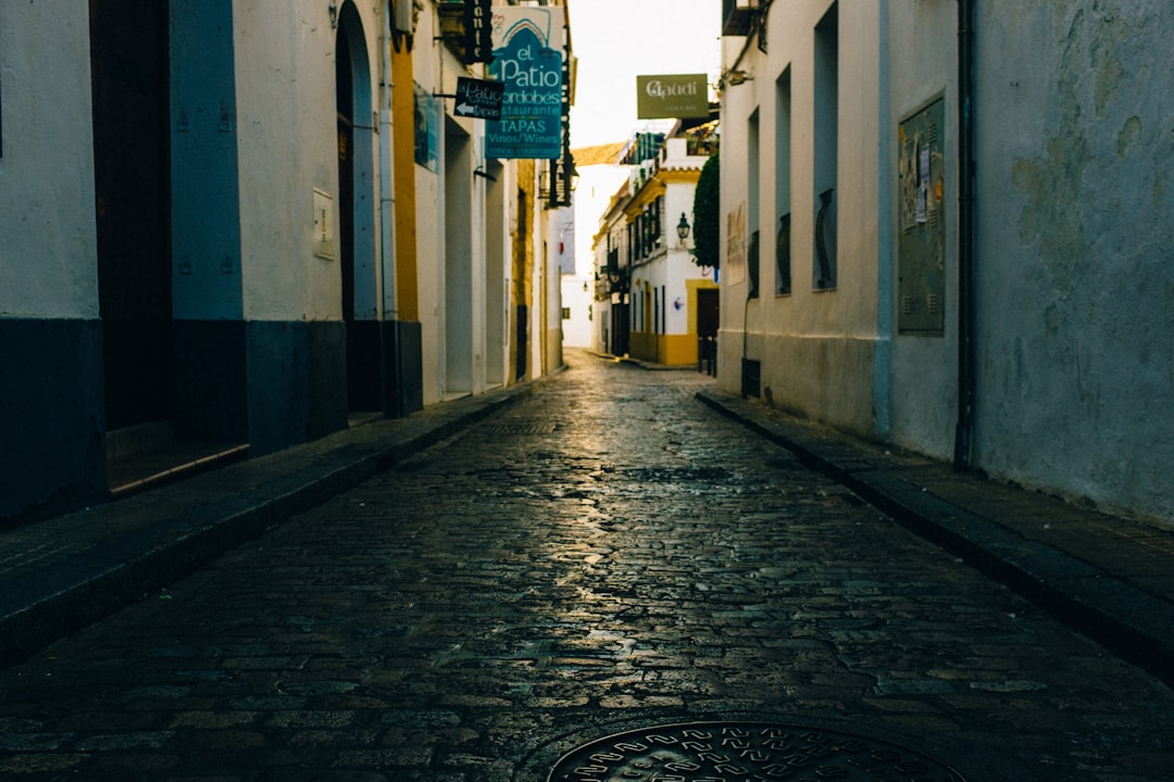 empty street between white concrete buildings during daytime