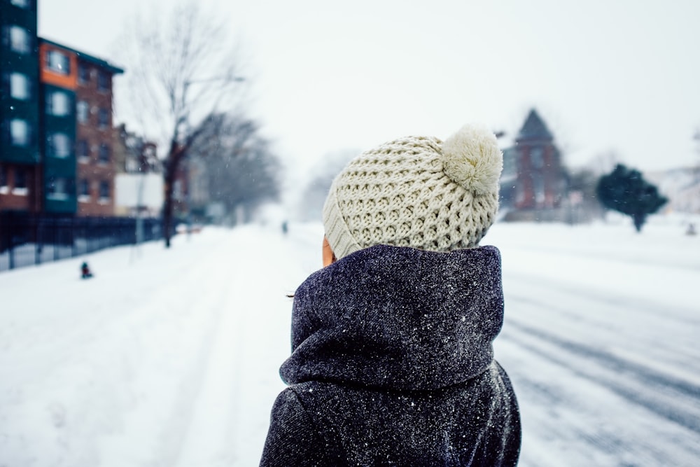 donna in piedi sulla strada coperta di neve