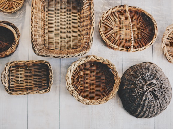 Handwoven rattan kitchen baskets arranged on a rustic wooden table