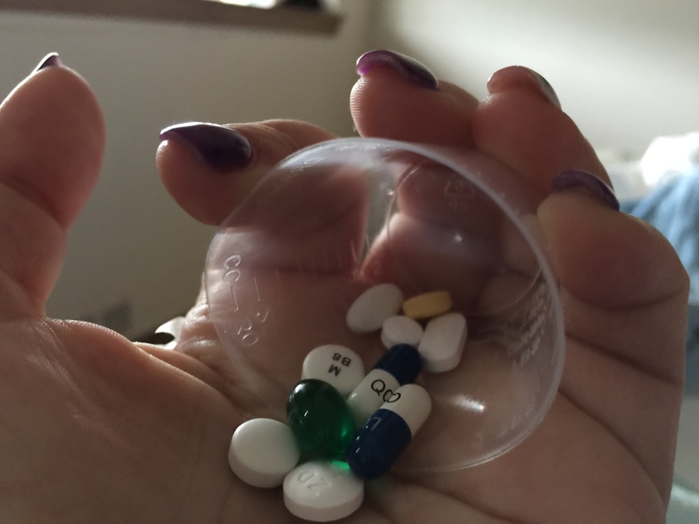Une petite boule en plastique pleine de comprimés et de capsules.