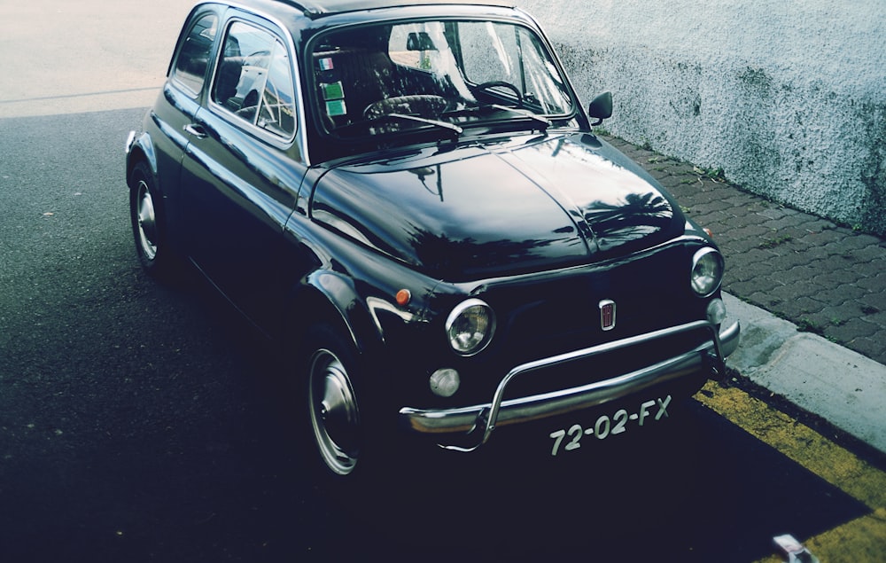 black 3-door hatchback parked near gray concrete wall outdoor