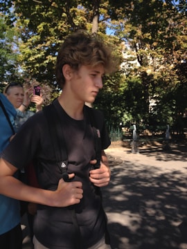 A mentor guiding a young person in a park.