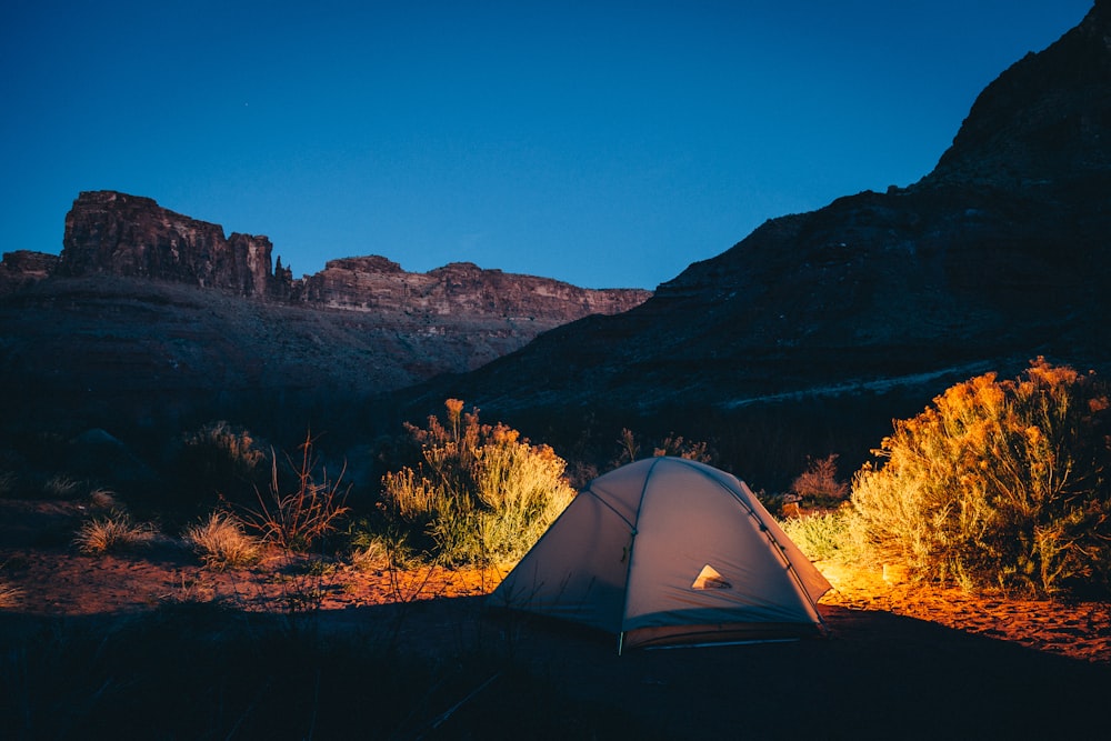 Tente de camping blanche à côté de la montagne