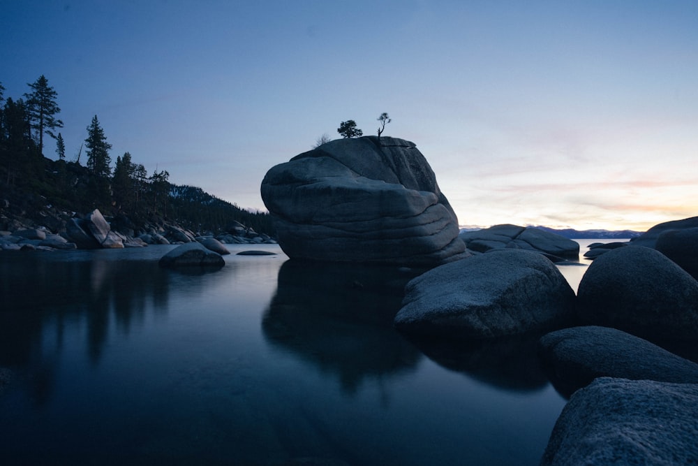 Formation rocheuse sur le plan d’eau au coucher du soleil