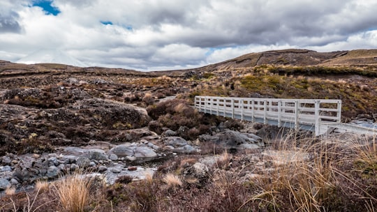 photo white bridge under white clouds at daytime in Tongariro National Park New Zealand