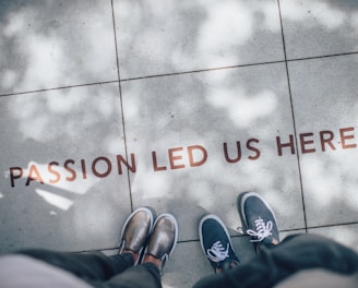 two person standing on gray tile paving with words "passion led us here"