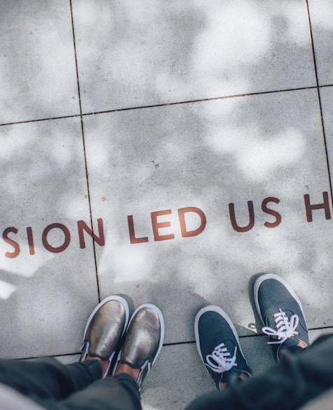 two person standing on gray tile paving