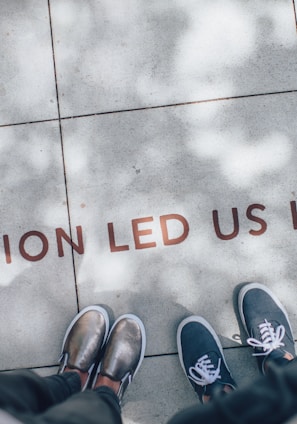 two person standing on gray tile paving