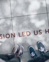 two person standing on gray tile paving