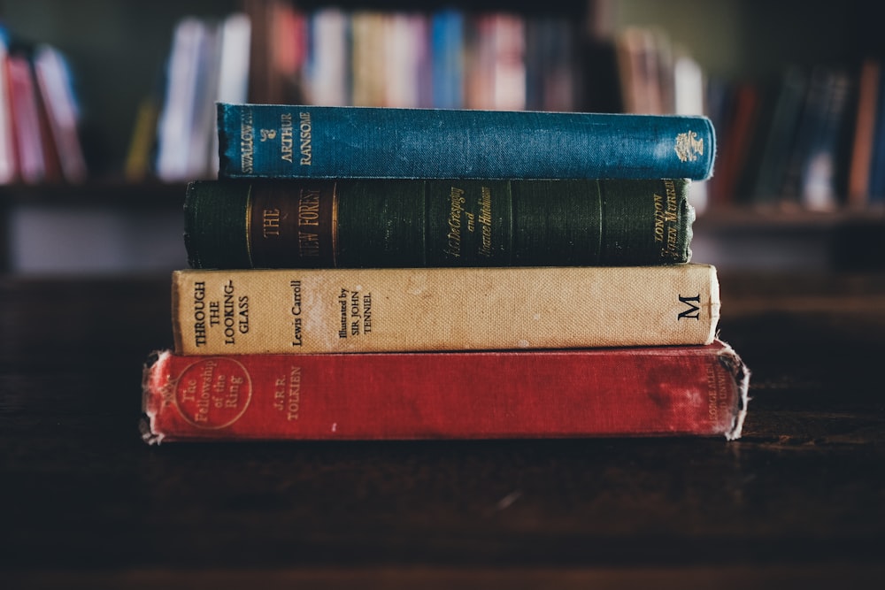 four assorted reading books on brown surface