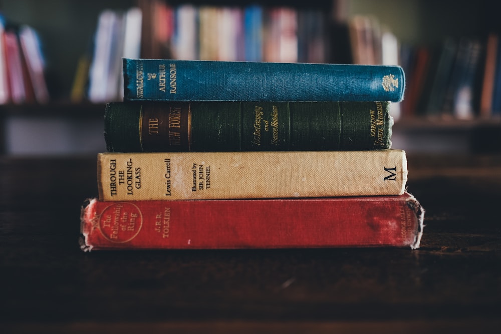 Cuatro libros de lectura variados sobre superficie marrón