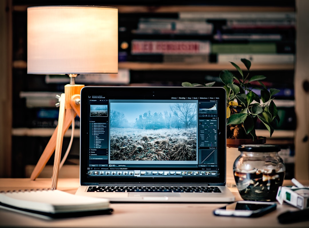 MacBook Pro on brown wooden table inside room, Photo editing laptop