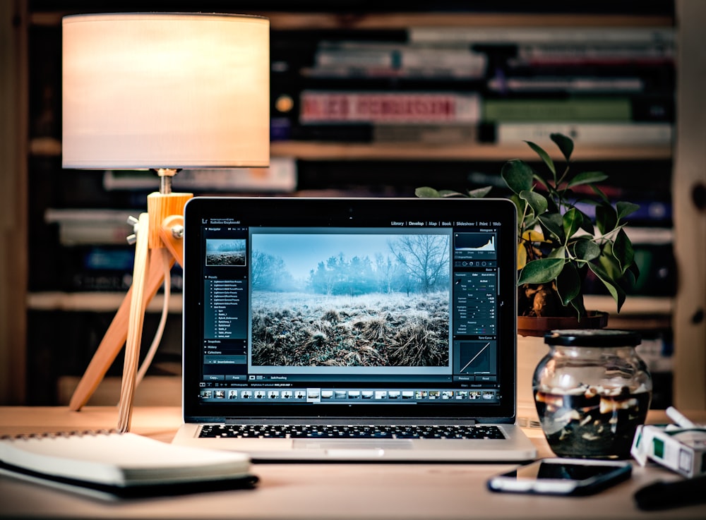 部屋の中の茶色の木製テーブルの上のMacBook Pro