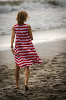 A woman walking along the shore in stylish strappy sandals.