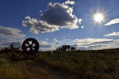 Rural landscape with crops and farm equipment under a clear sky.