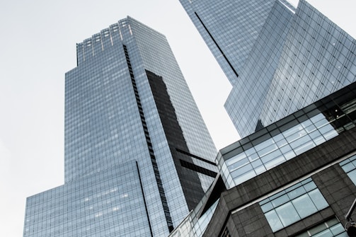 Tall, modern skyscrapers with reflective glass facades reach into a clear sky, conveying a sense of urban sophistication and grandeur.