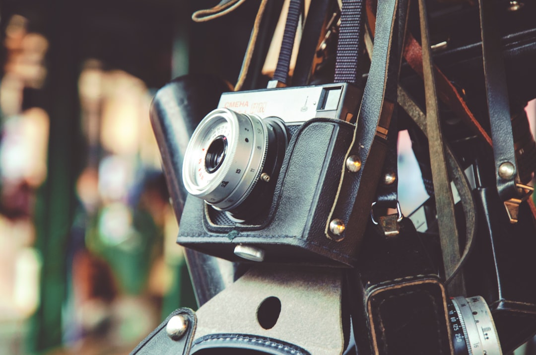 gray and black digital camera and black leather bag