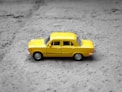 yellow sedan die-cast on gravel