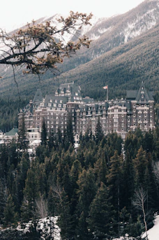 Flagship Sultan Resort entrance framed by tall pine trees and mountain views.