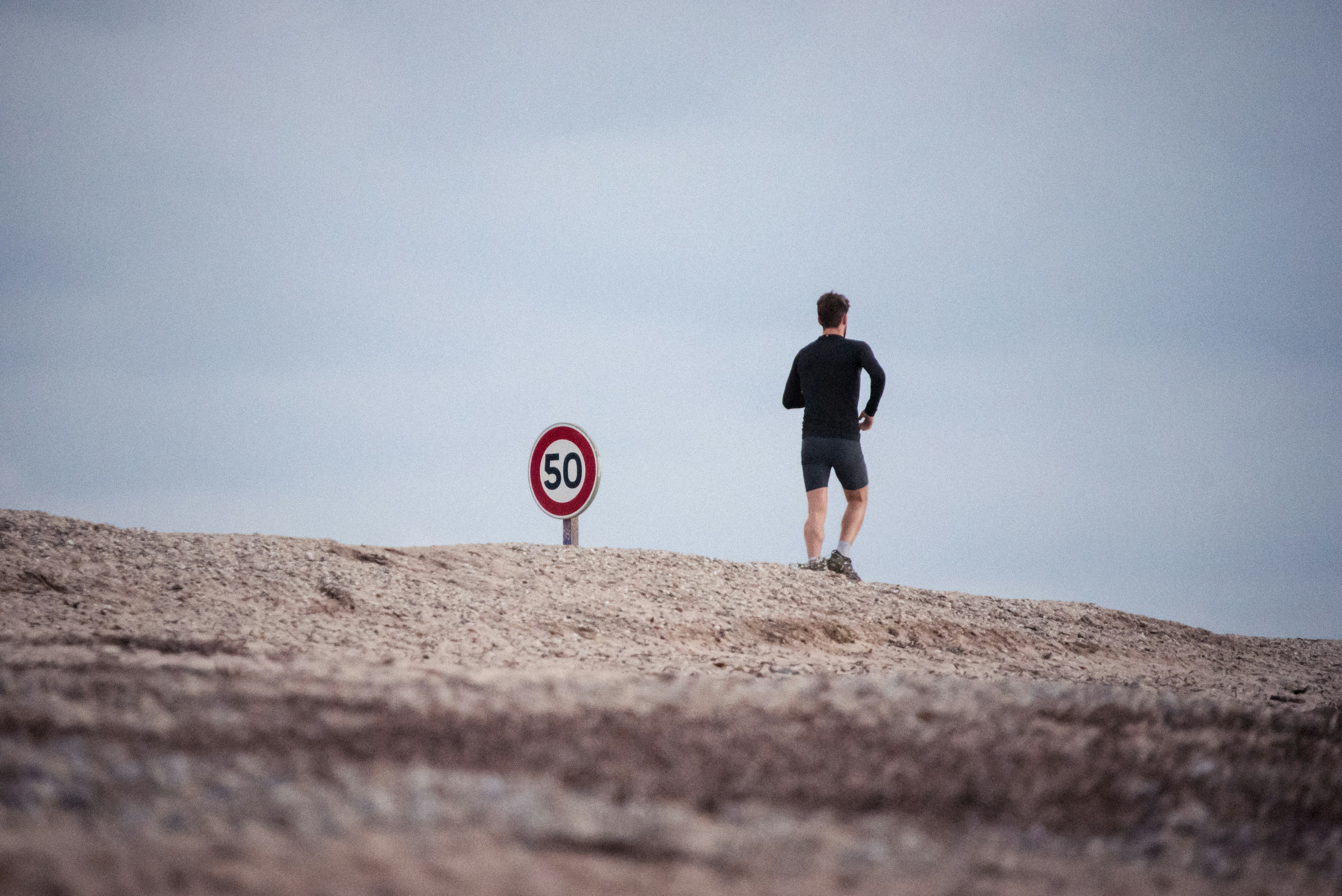 Guy jogging by sign
