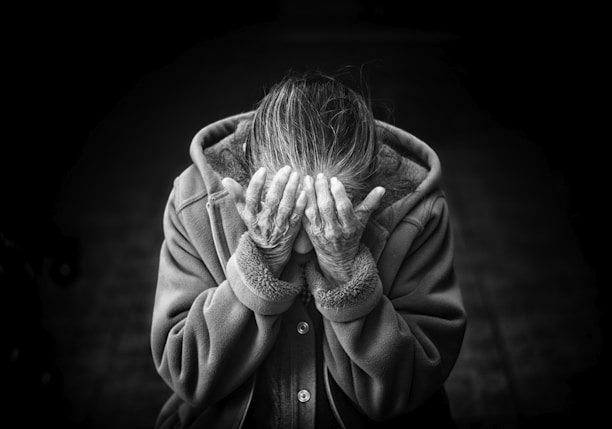 grayscale photography of person covering face