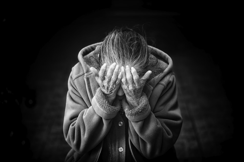 grayscale photography of person covering face