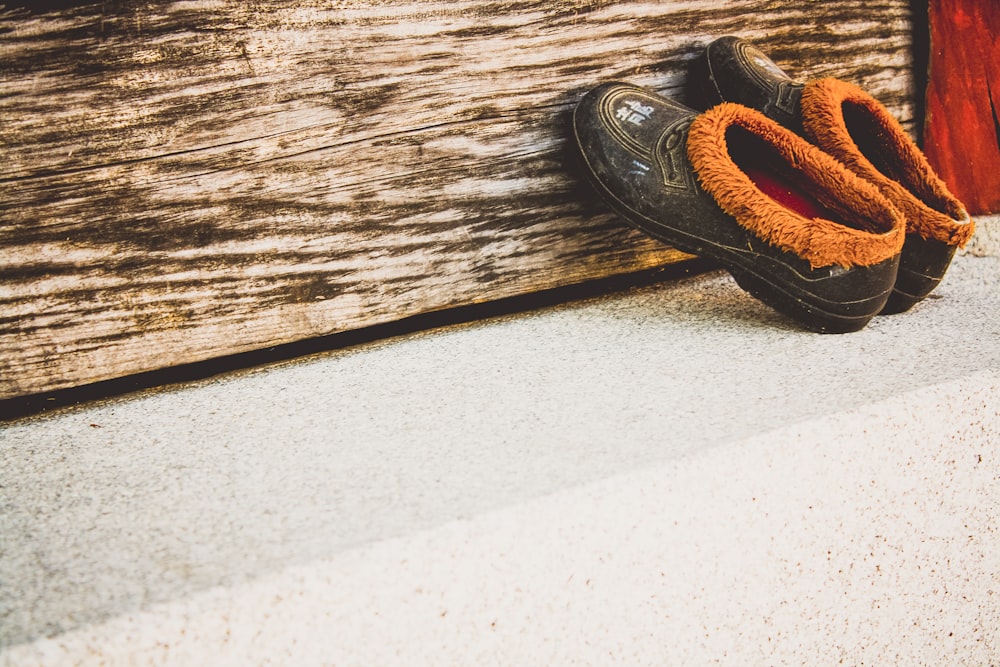 pair of black moccasins shoes leaning on wall