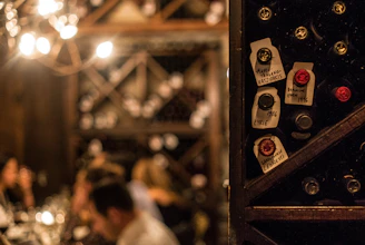 Close-up of a rustic wooden wine rack filled with assorted wine bottles in a cozy restaurant setting