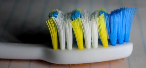 Close-up of toothpaste being squeezed onto a toothbrush with a soft, clean background.