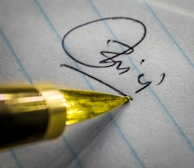 Close-up of hands signing a contract with a pen.