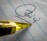 A close-up view of a pen tip positioned on a piece of lined paper with a signature partially visible. The pen's golden color contrasts with the paper's blue lines.