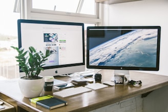 A dual monitor setup on a brown desk- lm universal clean