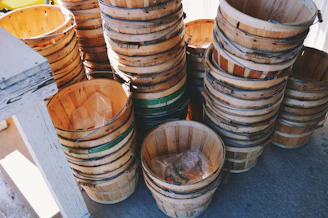 A set of nesting storage baskets in natural fibers, stacked inside each other on a sunlit balcony.