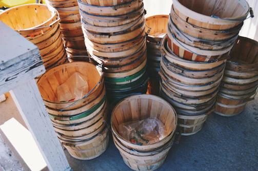 A set of nesting storage baskets in natural fibers, stacked inside each other on a sunlit balcony.