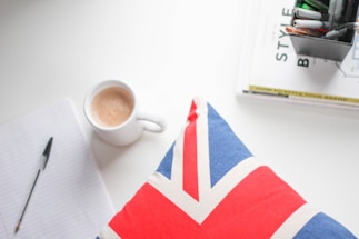 A warm, inviting workspace with a notebook, pen, and a cup of coffee ready for correspondence.