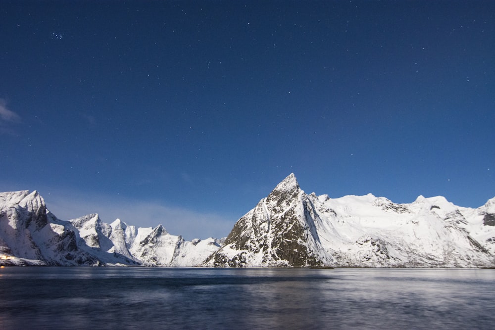 lake near mountain covered with snow