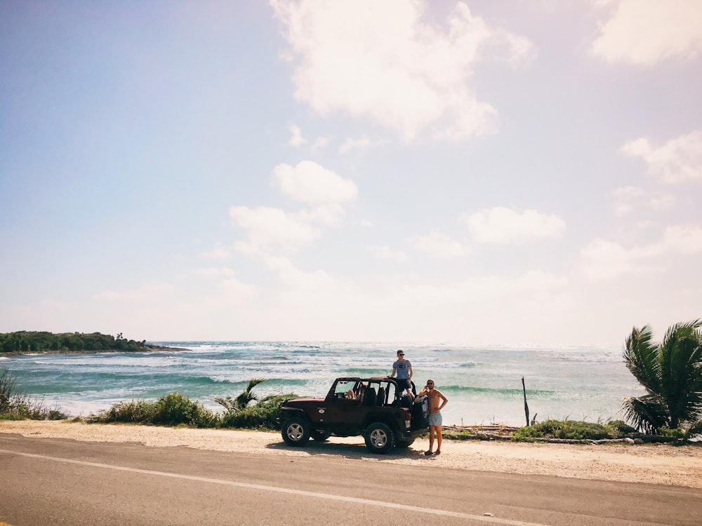 two men on brown SUV at daytime