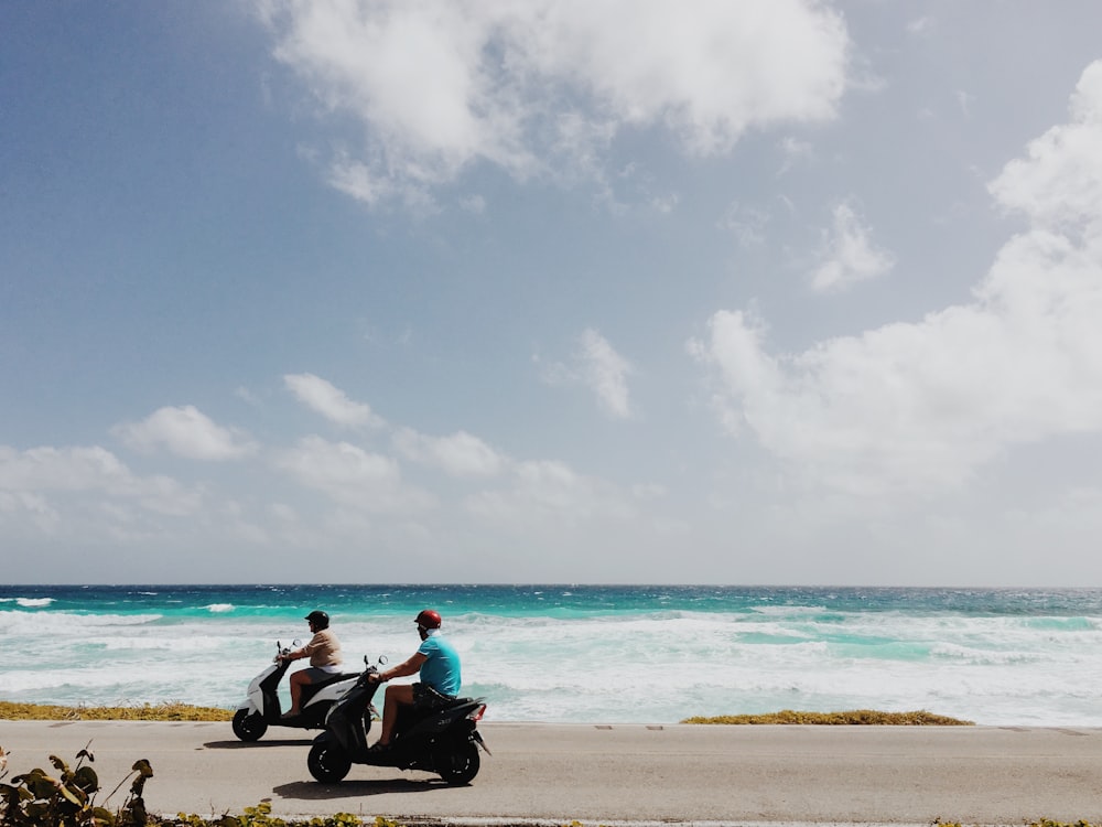 Menschen, die am Strand Motorrad fahren