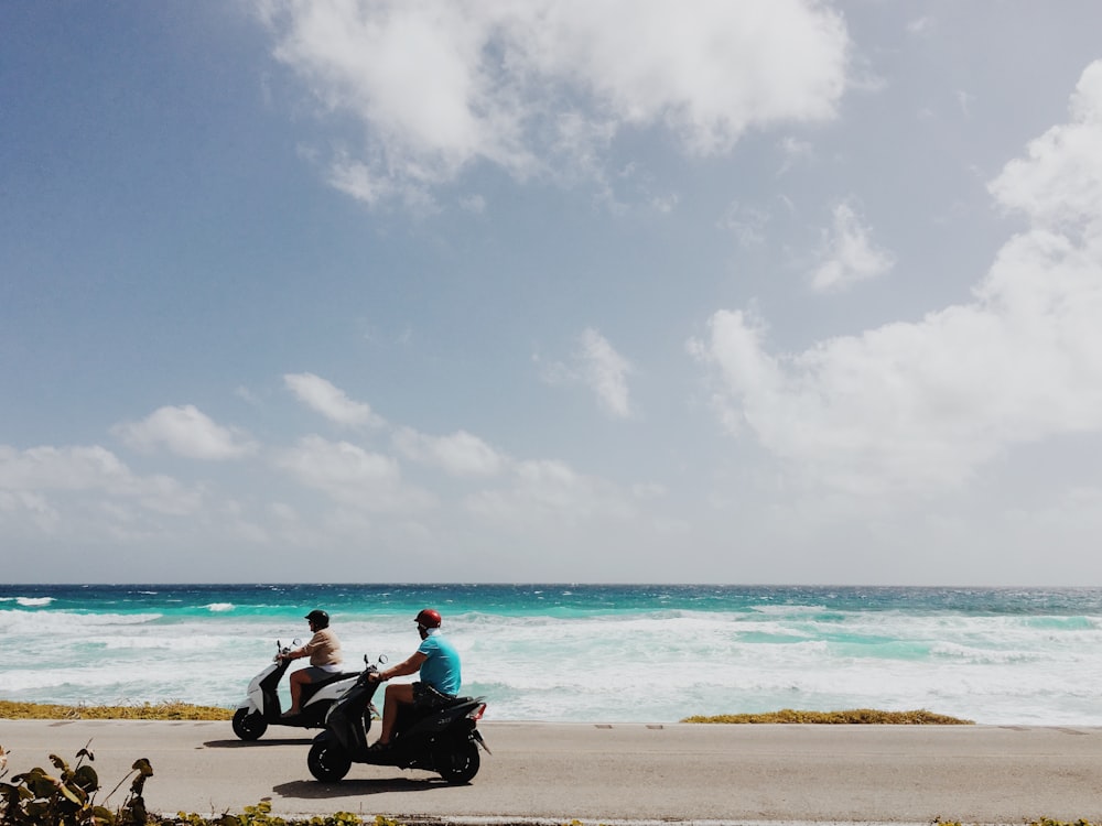 Gente montando en motocicleta en el lado de la playa