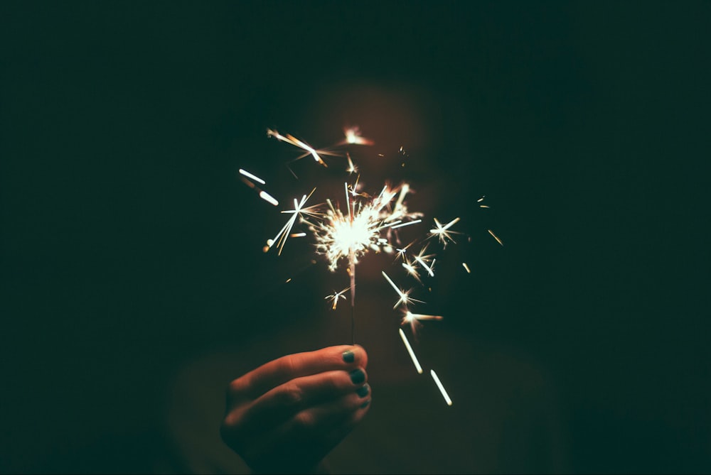 person holding lighted sparkler