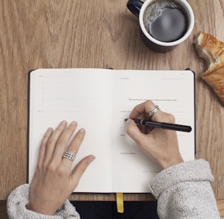 person writing on a book