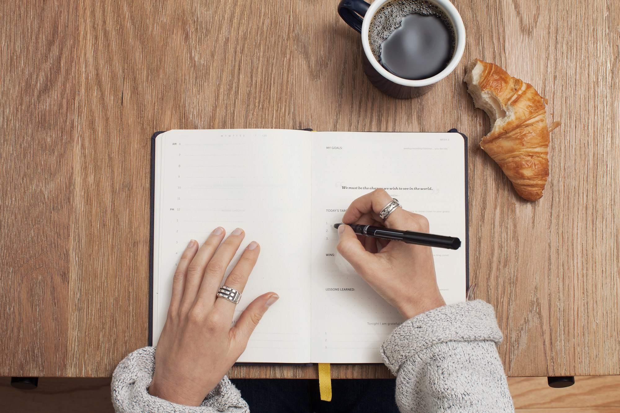 Escrevendo uma biografia no caderno e tomando café