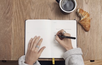 person writing on a book