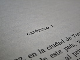 A close-up of a text document with the word 'CAP&Iacute;TULO I' centered in bold black letters on a white page. The lower part of the image shows additional text lines, partially visible and fading out of focus.