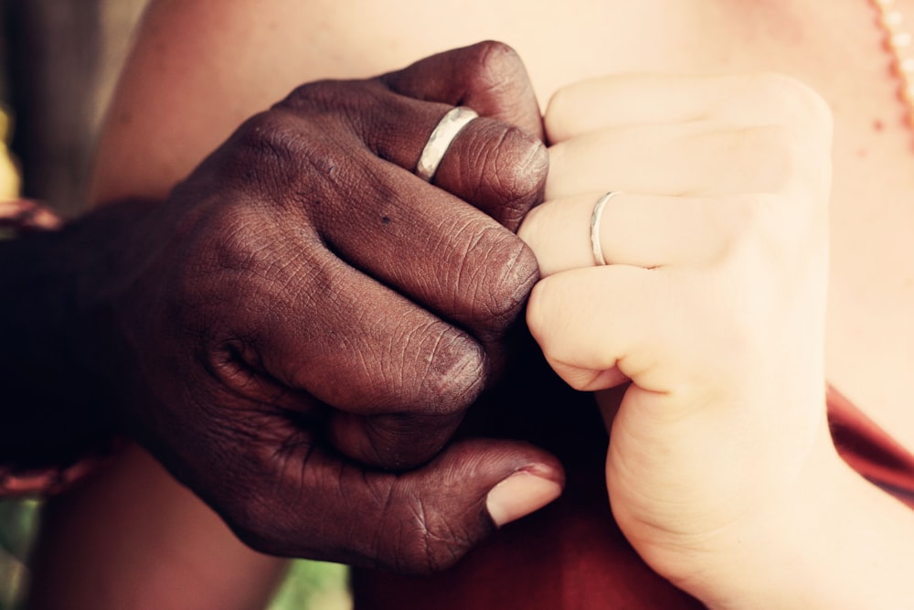 two person showing silver-colored rings