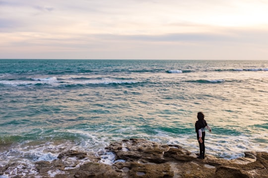 man in black shirt standing on rocky shore during daytime in Cádiz Spain