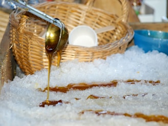 Close-up of rich, dark kithul syrup being poured over a bowl of tropical fruits.