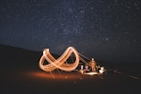 Campfire scene with influencers sharing gear reviews under starry sky.