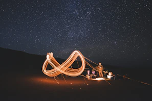 A heavy-duty camping cot stretched out under a starry night sky in the woods